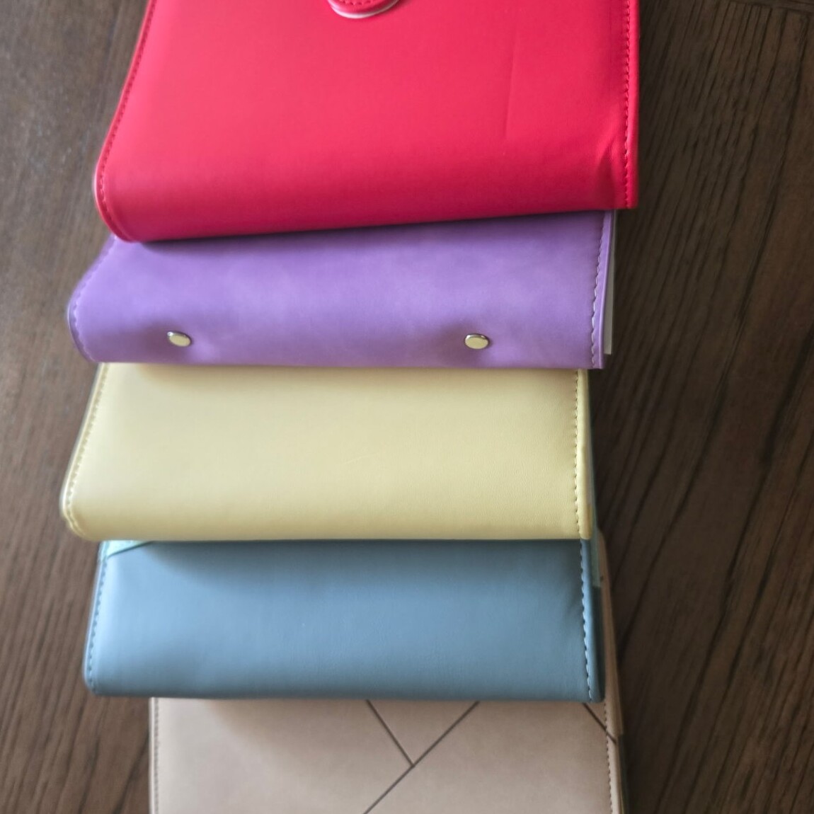 Stack of $aving Grace binders in red, purple, yellow, blue and beige