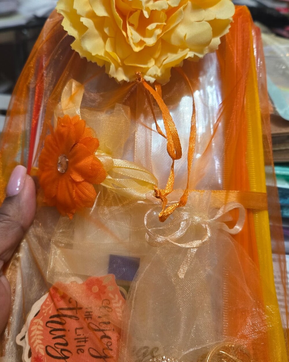 Orange organza gift bag with stickers, bling charms and a flower