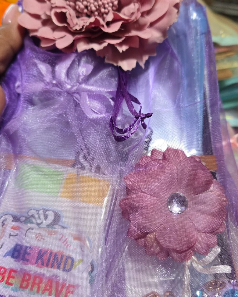 Purple organza gift bag with stickers, charms and a flower